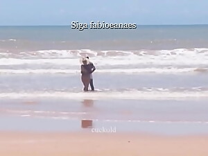 (TRECHO) Sarro gostoso interracial da howife. Esposa gostosa de biquini se exibe na praia e pega no pauzã_o do negã_o de sunga branca e recebe massagem na frente do corno.